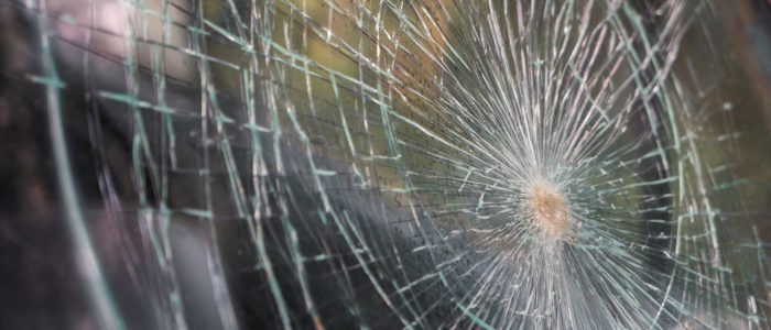 Glass broken cracks splinters in front of car ( Filtered image processed vintage effect. )